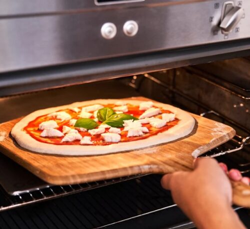 בתוך התנור פיצה יורדת עליו משטח ברזל אפיה אוני גודל 34 סמ Ooni Pizza Steel 13